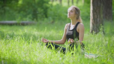 Sakin sportif kadının'ın bahçesinde yoga poz güneş ışığı