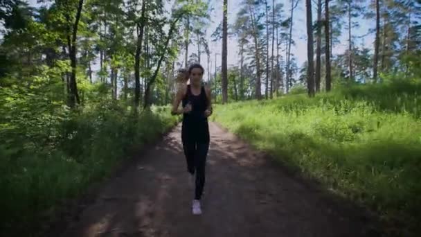 Alkalmas sportos nő egyedül jogging út-zöld erdőben — Stock videók