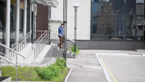 Businessman walking and talking smartphone. Side view of adult confident manager talking his smartphone and walking downstairs. — Stock Video