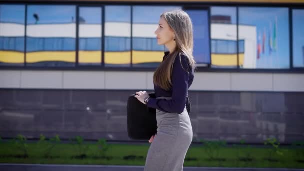 Confident businesswoman walking at office. Side view of confident young female entrepreneur walking at office building. — Stock Video