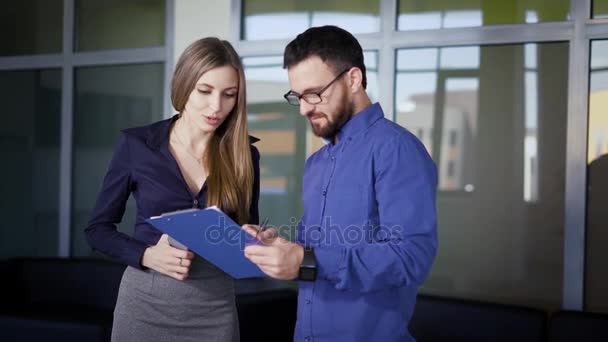 オフィスで書類に署名する人。オフィスの男性と女性従業員の同僚の立っているとドキュメントの署名. — ストック動画