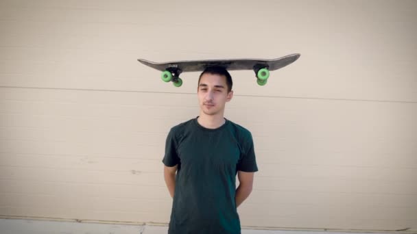 Portrait of funny skateboarder. Young man holding skateboard — Stock Video