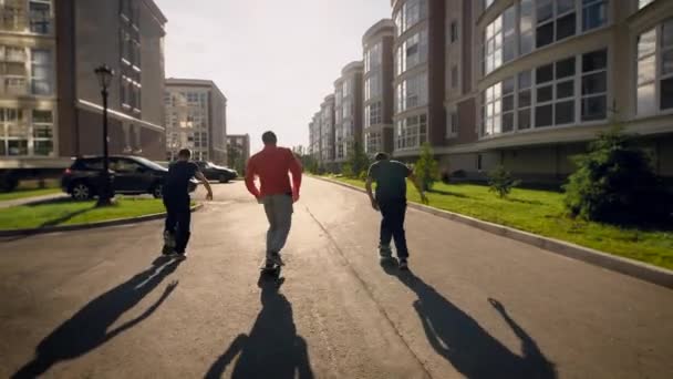Jonge vrienden skateboarders wandelen rond de stad samen — Stockvideo