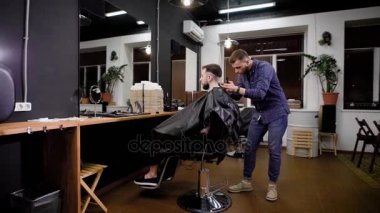 Kuaför berber koltuğuna oturan istemci kesme makinesi uygulamak