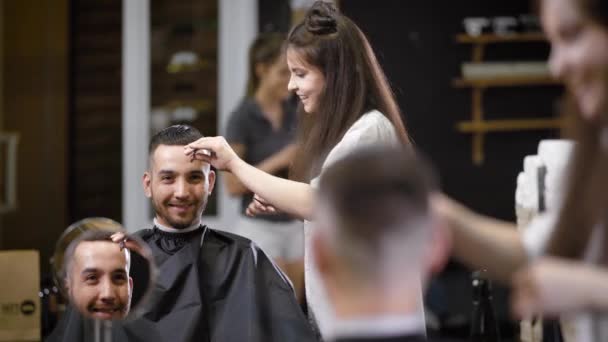 Leende klienten tittar på reflektion medan kvinnlig Frisör att göra sitt hår i salong. — Stockvideo