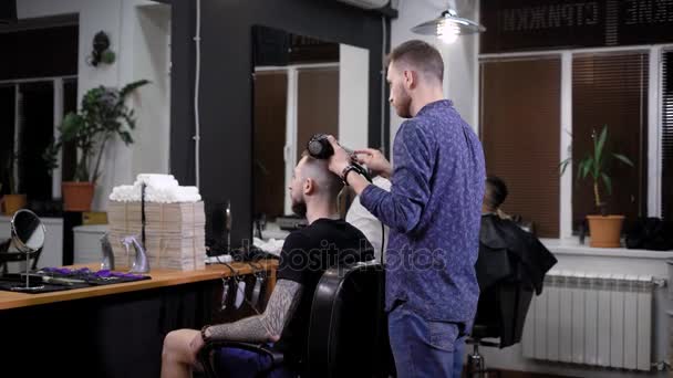 Κομμώτρια που χτενίζει τα μαλλιά κομψά αρσενικό πελάτη στο κουρείο — Αρχείο Βίντεο