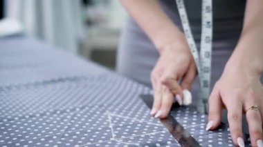 Genç terzi dikiş için bant ile doku ölçümler yaparak