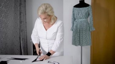 Kadın tecrübeli terzi kesim kumaş terziler makas ile kesme.