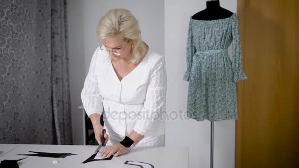 女性経験豊富な仕立て屋仕立て屋ハサミで布をカット. — ストック動画