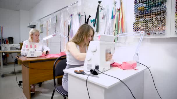 Jovens costureiras e idosos alfaiate no trabalho em alfaiataria trabalhando juntos — Vídeo de Stock