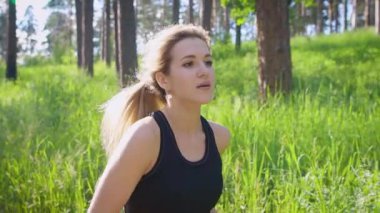 Yavaş çekim park bölge'den Bayan etrafına bakıyor ve doğa sever aktif olarak çalışan bir güzel ve genç bir kadın