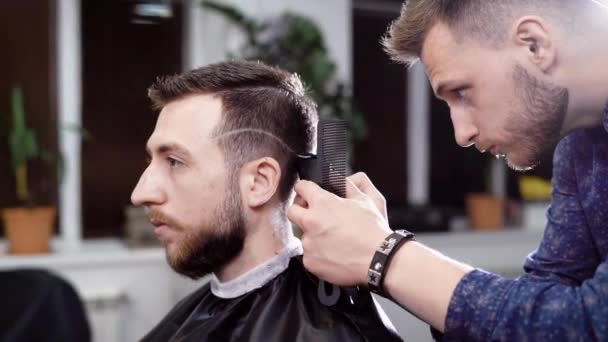 Peluquero y cliente masculino. Peluquería haciendo el peinado con cortador. Escena de la peluquería — Vídeos de Stock