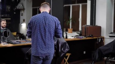 Hipster adam mükemmel trim kuaför dükkanında alıyorum. sandalyede otururken. Tıraş kesme makinesi kullanarak Kuaför