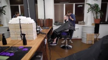 Kadın ve erkek Berber saç kesimi üzerinde erkek hipsters müşteriler yapma.