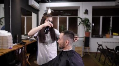 Adam hipster ziyaret berber dükkanı. Kadın berber yapım şık saç kesimi. Kuaför Salonu iç görünümü