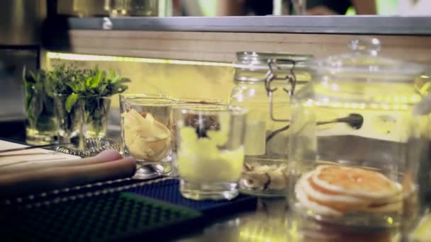 Крупним планом знімок інгредієнтів, які стоять на барній стійці, спеції, ягоди та інші добавки знаходяться в скляній мисці — стокове відео