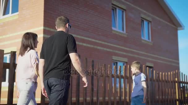 Hijo alegre y padres felices disfrutando de un nuevo lugar de vida — Vídeos de Stock