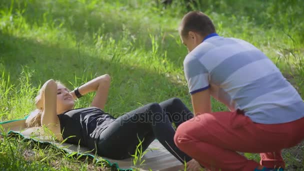 Mujer haciendo abdominales ejercicio de prensa en el parque . — Vídeos de Stock