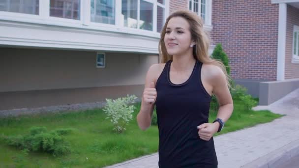 Mulher caucasiana bonita correndo na rua. Desporto e estilo de vida saudável — Vídeo de Stock