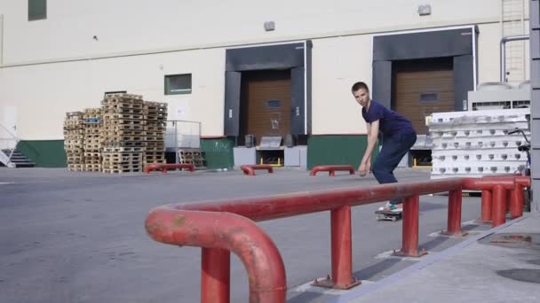 Teenager springt auf Skateboard über rotes Geländer im Skaterpark. Skateboarder beim Nasenschleifen auf der Funbox im Freien. Junge treibt im Sommer Extremsport. — Stockvideo