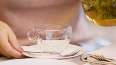 kadın bir yeşil çay restoranda cam bardağa yaz tatile yağıyor