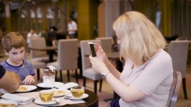Anne neşeyle resim çocuğunun babası ona yardım ediyor iken masada yemek alıyor