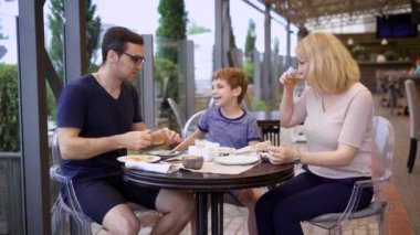 Aile hep birlikte restoranda yemek keyif alıyor gülüyor ve birbirleri ile sohbet
