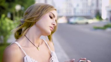 Genç sevimli kadın yolun duran ve yaz döneminde onun selfies fotoğraflarını izlerken