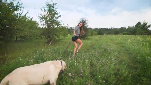 Mladá žena, běh přes pole se psem — Stock video