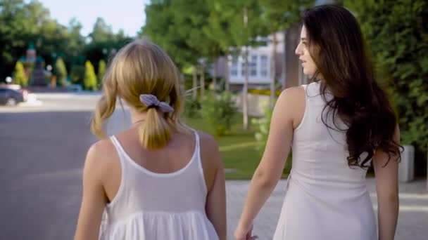 두 젊은 슬림 여성 회담, 좋은 화창한 날씨, 아니 바람 여름에 공원에서 산책의 뒷면 — 비디오