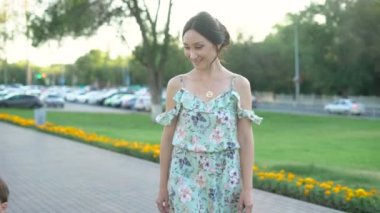 Küçük şirin oğulları sevimli yeallow motosiklet sürme iken güzel aile parkta yürüyor