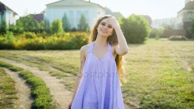 Güzel ve genç bir kadın giriyor kırsal üzerinde neşeli bir ruh, bir Bayan sarafan gülümsüyor ve kafasını uzun kıvırcık saçlı wags