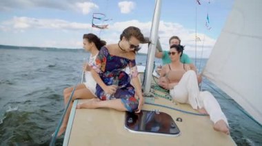 Mutlu grup arkadaşıyla birlikte deniz bir yatta yelken, gülen, sohbet ve sadece ürpertici eğleniyor