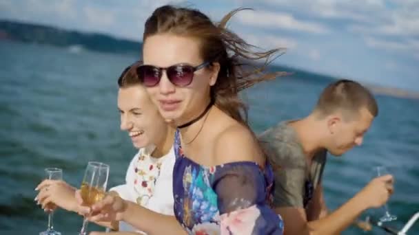 Pequeno grupo de amigos estão festejando no iate, rindo alto e bebendo champanhe navegando pelo mar . — Vídeo de Stock