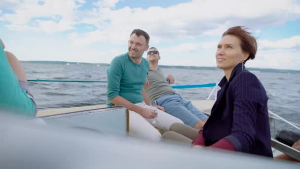 Cuatro viejos amigos sentados en un yate, navegando por el mar, bebiendo champange y charlando sobre cosas — Vídeo de stock