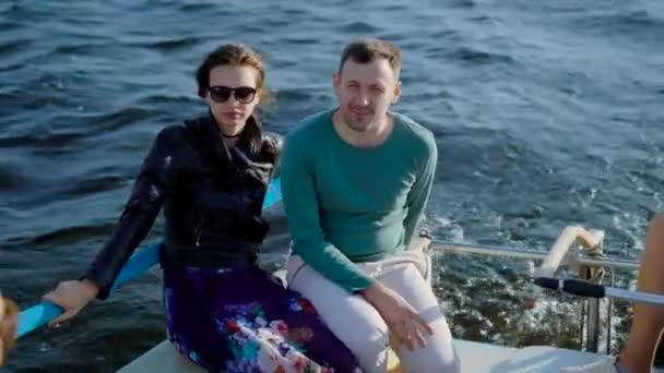 有吸引力的年轻夫妇，一起低温冷害对享受明亮的一艘游艇热阳光灿烂的日子，在海上航行的度假 — 图库视频影像