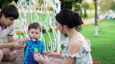 genç esmer erkek ve kadın küçük oğulları darbe baloncuklar Park Yaz günde öğretiyoruz