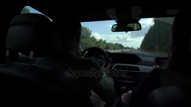 Hombre está conduciendo coche y la mujer está encontrando la derrota por el navegador, sentado dentro de un coche en movimiento durante el día en verano — Vídeo de stock