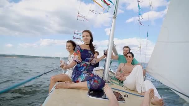 Cheerful group of young friends having party on modern yacht