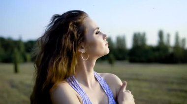 Rüya, merak ve yaz güneşi sıcak gülümseyen alanında tek başına duran güzel genç kadın