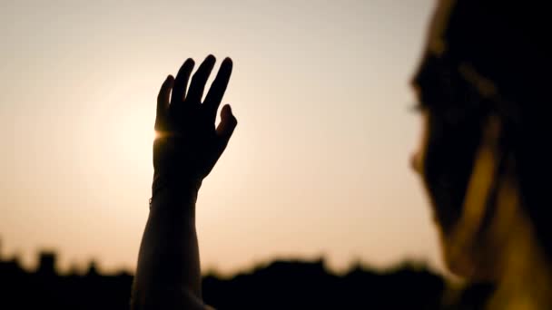 De pie solo en el campo de la mujer desesperadamente tratando de coger el sol durante la puesta del sol, pero ella no puede, vista increíble — Vídeos de Stock