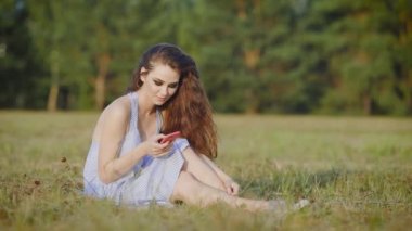 Tarama, arkadaş ve kahkaha ile sohbet alanında onun smartphone ile tek başına oturmak Attracitve kadın