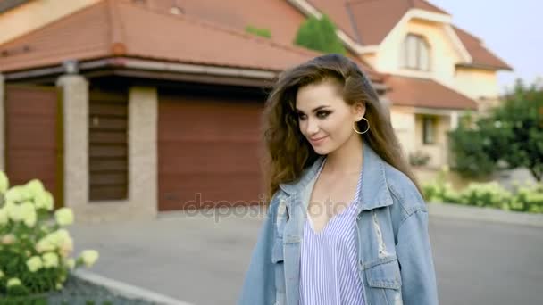 Increíble joven mujer camina por la calle vistiendo chaqueta jeans, vestido azul y sonriendo increíblemente — Vídeo de stock