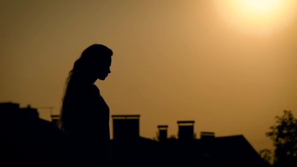 Νέοι και unbelievebly όμορφη γυναίκα, πηγαίνει μόνο για μια βόλτα στο πεδίο για να απολαύσετε ένα από τα τελευταία καλοκαιρινά ηλιοβασιλέματα — Αρχείο Βίντεο