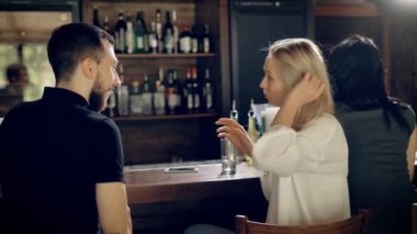 Restoranda tarihi olan sevgi dolu bir çiftin yakın çekim. Genç adam ve güzel kadın sayaç oturup birbirlerine söz. Kız arkadaşı gülerek ve gülümseyerek ile flört ediyor.