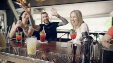 Taze kokteyl yapmak bir barmen eller yakın çekim. Adam Bar counter içecekler onu oturan şirket için hazırlanıyor. Genç hipster iki kız arkadaşım için onun mutluluğu ifade.