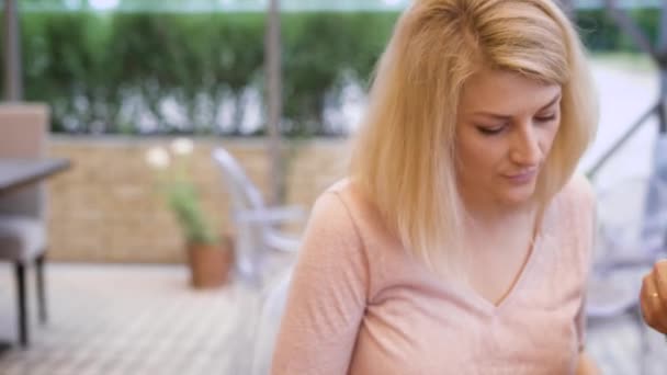 Una joven pareja familiar con un hijo está comiendo en la cafetería en el día de verano. Primer plano del hombre guapo y hermosa mujer menú de lectura y la elección de la comida con mesas y árboles en el fondo . — Vídeos de Stock