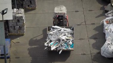Metal ve diğer enkaz onun geri dönüşüm için bir yol asfalt ve gelecekte kullanılmak üzere sıralama boyunca Ekskavatör taşır
