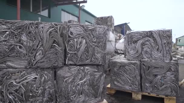 Tuyaux métalliques pressés pour le recyclage, les déchets triés sont pressés et se tient sur une palette, est dans la rue dans l'usine — Video