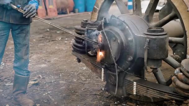 L'uomo che è impegnato nella lavorazione secondaria separa le parti metalliche della ruota dal tram, le scintille volano in direzioni diverse. — Video Stock